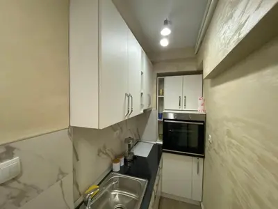 a small kitchen with white cabinets and a sink at Daca 2 in Belgrade