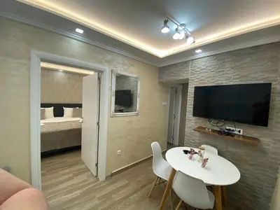 a living room with a white table and a tv at Daca 2 in Belgrade