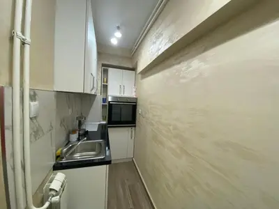 a small kitchen with white cabinets and a sink at Daca 2 in Belgrade