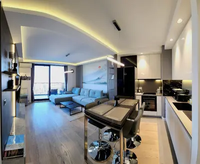 a kitchen and living room with a blue couch at Belgrade Waterfront 16th fl Lux Apt. w/ City view in Belgrade