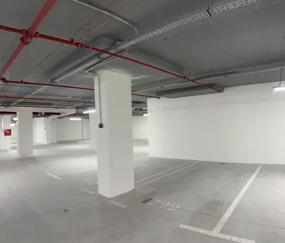 an empty parking lot with white columns in a parking garage at Belgrade Waterfront 16th fl Lux Apt. w/ City view in Belgrade