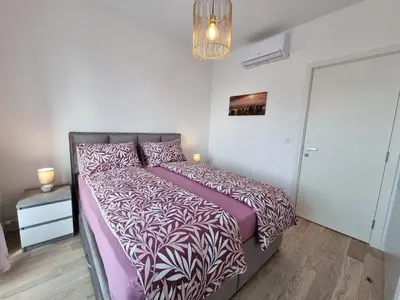 a bedroom with a bed with a purple comforter at BW Aria deluxe apartments in Belgrade