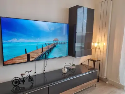 a large flat screen tv hanging on a wall in a living room at BW Aria deluxe apartments in Belgrade