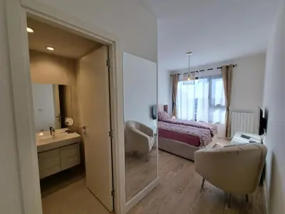 a bathroom with a mirror and a bedroom with a bed at BW Aria deluxe apartments in Belgrade