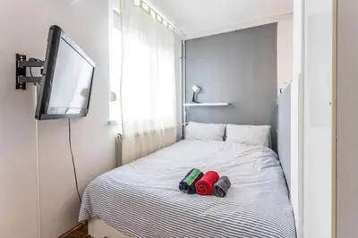 a bed with two slippers and a television on it at Lovely Studio with a big terrace in Belgrade