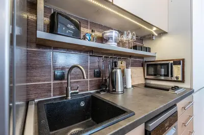 a kitchen with a sink and a microwave at Lovely Studio with a big terrace in Belgrade