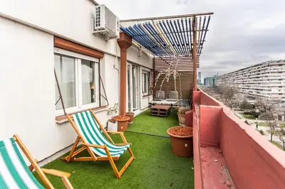 a patio with two chairs and a table on a balcony at Lovely Studio with a big terrace in Belgrade