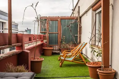 a patio with a chair and potted plants on a balcony at Lovely Studio with a big terrace in Belgrade