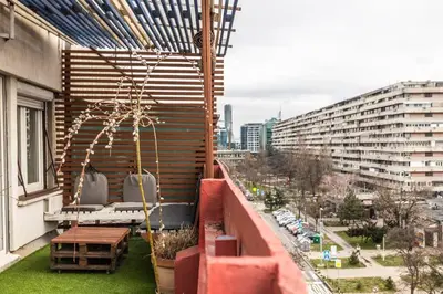 a balcony with a table and chairs on a building at Lovely Studio with a big terrace in Belgrade