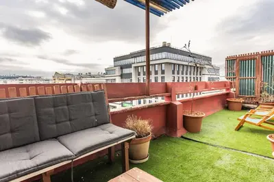 a balcony with a couch on a roof at Lovely Studio with a big terrace in Belgrade