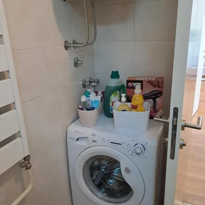 a washing machine with cleaning products on top of it at Manhattan apartman Zumbul Belvil in Belgrade