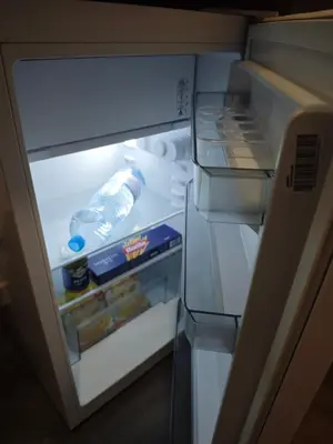 an open refrigerator with a bottle of water and food at Dunja Apartmans in Belgrade