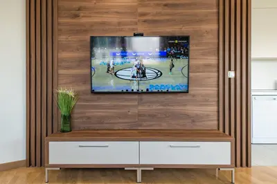 a television on a wooden wall in a living room at Luxury Stay in Belgrade Waterfront with Views in Belgrade