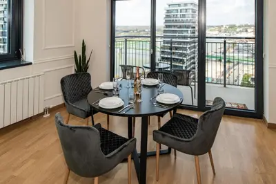 a dining room with a table and chairs and a balcony at Luxury Stay in Belgrade Waterfront with Views in Belgrade