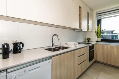 a kitchen with white counters and a sink and a window at Luxury Stay in Belgrade Waterfront with Views in Belgrade