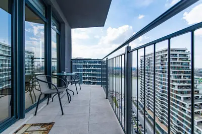 a balcony with chairs and tables on a building at Luxury Stay in Belgrade Waterfront with Views in Belgrade