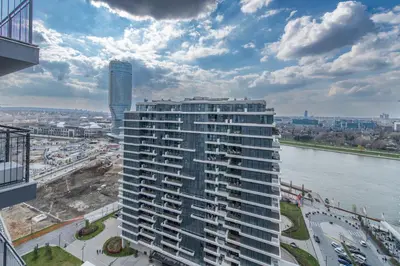 a view of a tall building next to a river at Luxury Stay in Belgrade Waterfront with Views in Belgrade