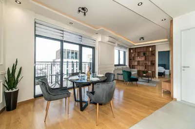 a living room with a dining room table and chairs at Luxury Stay in Belgrade Waterfront with Views in Belgrade