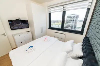 a bedroom with two white beds and a large window at Modern Luxury in Belgrade Waterfront with Views in Belgrade