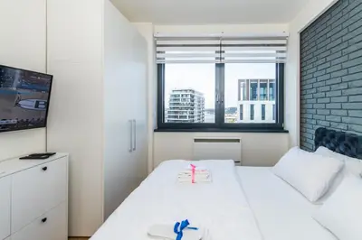 a small bedroom with a white bed and a window at Modern Luxury in Belgrade Waterfront with Views in Belgrade
