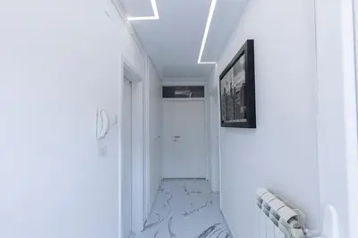 a hallway with marble flooring and a white door at DULE’S HOUSE in Belgrade