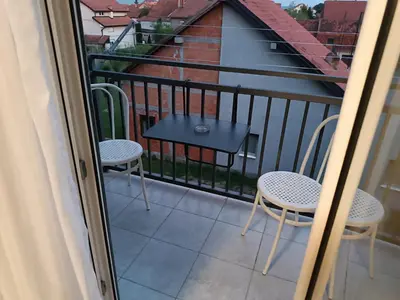 a balcony with two chairs and a table at Apartman Mima in Borča