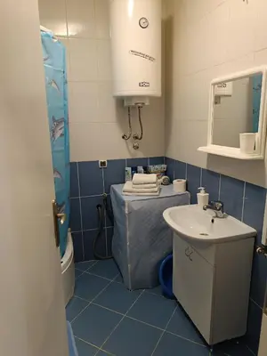 a blue bathroom with a sink and a mirror at Apartman Mima in Borča