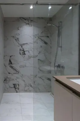 a bathroom with a glass shower with a sink at Lovely Studio Apartment - Belgrade Waterfront - Free Parking in Belgrade