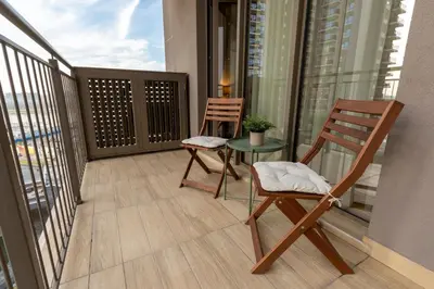a balcony with two chairs and a table on it at Lovely Studio Apartment - Belgrade Waterfront - Free Parking in Belgrade