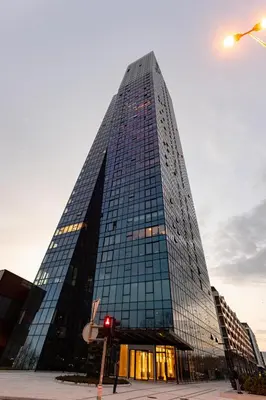 a tall glass building with a red traffic light at In The Sky - Apartment West 65 Tower in Belgrade