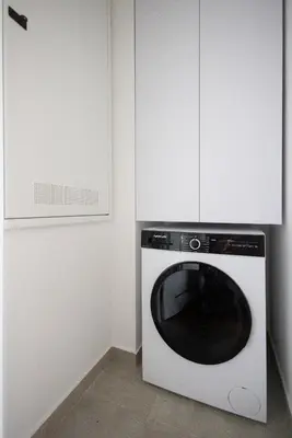 a black and white dishwasher in a kitchen with white cabinets at In The Sky - Apartment West 65 Tower in Belgrade