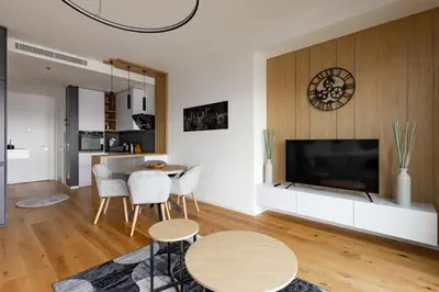 a living room with a television and a table and chairs at In The Sky - Apartment West 65 Tower in Belgrade