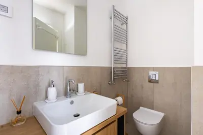 a bathroom with a white sink and a toilet at In The Sky - Apartment West 65 Tower in Belgrade