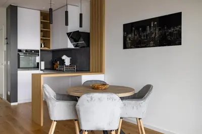 a kitchen and dining room with a wooden table and chairs at In The Sky - Apartment West 65 Tower in Belgrade