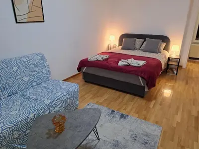 a bedroom with a bed and a couch and a chair at Apartment Bruno NICE PLACE in Belgrade