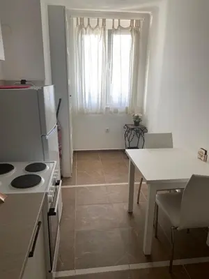 a kitchen with a table and a white refrigerator and a table at Apartment Bruno NICE PLACE in Belgrade