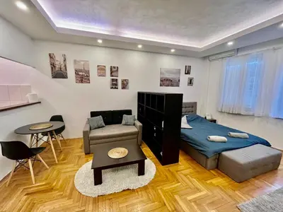 a bedroom with a bed and a couch and a table at Apartment ARENA 28 in Belgrade
