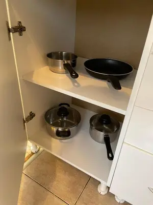 a kitchen with two pots and pans on a shelf at Apartman Helena in Lazarevac
