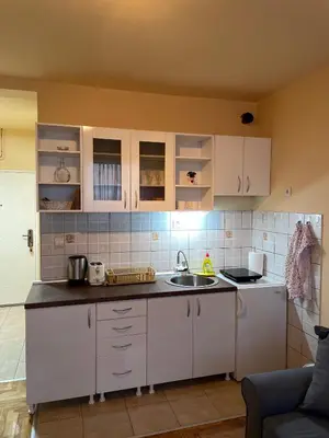 a kitchen with white cabinets and a sink at Apartman Helena in Lazarevac