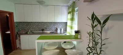a kitchen with white cabinets and a green counter at Despot 105 in Belgrade
