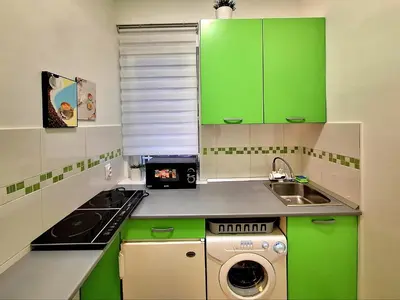 a small kitchen with green cabinets and a sink at GENIUS APARTMENT in Belgrade