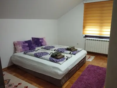 a bedroom with a bed with a purple comforter at Stan Ledine in Ledine