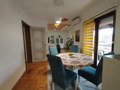 a dining room with a table and blue chairs at Stan Ledine in Ledine