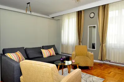 a living room with a black couch and two chairs at Kursula in Vračar (historical)