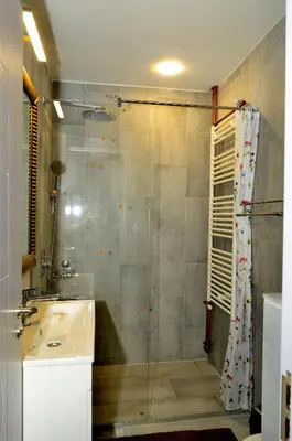 a bathroom with a glass shower and a sink at Kursula in Vračar (historical)