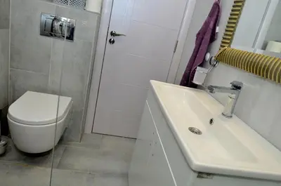 a white bathroom with a toilet and a sink at Kursula in Vračar (historical)