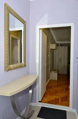 a bathroom with a mirror and a table and a hallway at Kursula in Vračar (historical)