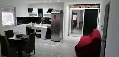 a kitchen and dining room with a red couch and a table at YOUR home in Belgrade