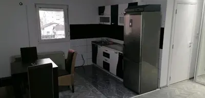 a kitchen with a refrigerator and a table and a window at YOUR home in Belgrade