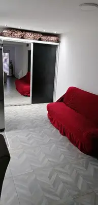 a bedroom with a red bed and a large window at YOUR home in Belgrade